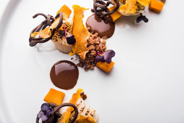 Artistic dessert plate with chocolate and mango